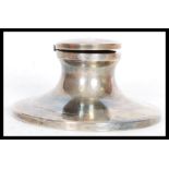 A hallmarked silver early 20th century capstan inkwell having a hinged lid on sloped circular