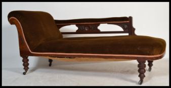 An Edwardian chaise longue with carved and pierced show wood frame and upholstered finish raised