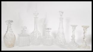 A collection of cut glass crystal decanters and candlesticks to include a tall decanter with an