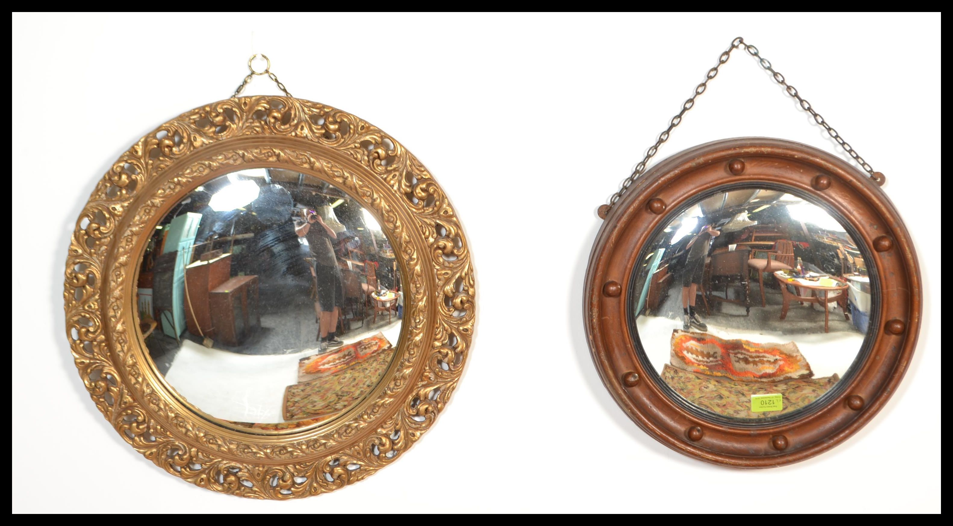 Two vintage 20th century comvex mirrors of circular form. One having a detailed ornate scrolled gilt