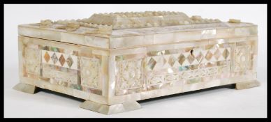 A early 20th century mother of pearl chest box raised on square feet with carved detailing to the