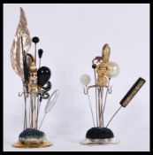 A collection of vintage hat pins contained on two
