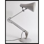 A 20th century vintage retro industrial style anglepoise desk lamp with a lilac pendant shade on a