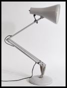 A 20th century vintage retro industrial style anglepoise desk lamp with a lilac pendant shade on a