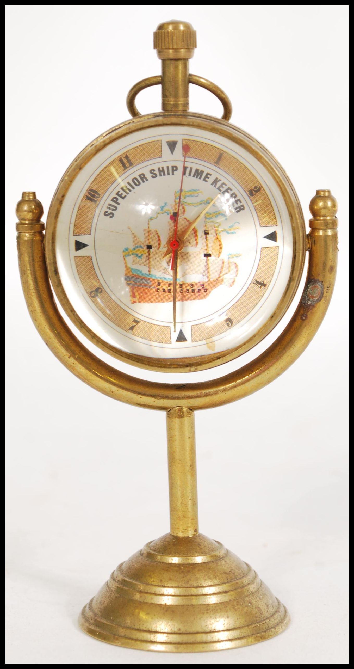 A contemporary brass Roman style fish eye ball clock raised on a brass base with nautical maritime