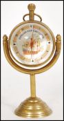 A contemporary brass Roman style fish eye ball clock raised on a brass base with nautical maritime