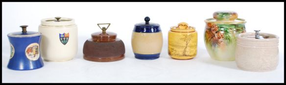 A selection of vintage tobacco jars to include a hand painted jar with painted pine cones, a Royal