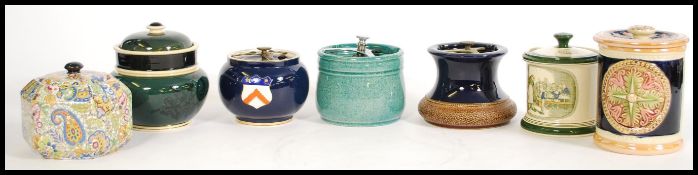 A collection of vintage tobacco jars to include a green and black jar with birds and florals to