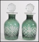 A pair of two small Victorian green cut glass perfume bottles with a cut glass finial stoppers.