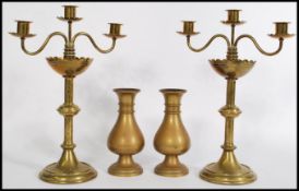 A pair of 19th century brass candelabras raised on stepped circular bases with scrolled arms and