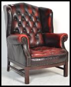 A 20th century Antique style oxblood leather chesterfield armchair being raised on cabriole legs