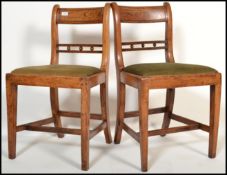 A pair of early 19th century Georgian elm country chairs having shaped back rests with drop in