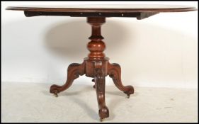 A Victorian mahogany 19th century pedestal dining table of rococo influence. Raised on quadruped