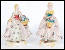 A pair of 20th century Italian continental figurines of ladies with baskets of flowers, stamped made
