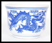 A Kang - Xi period Chinese tea bowl having hand painted blue and white decoration of Dragons chasing