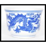 A Kang - Xi period Chinese tea bowl having hand painted blue and white decoration of Dragons chasing