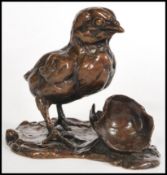 A bronze figurine of a chick and egg by Lucy Kinsella, signed to the base 'Kinsella', limited