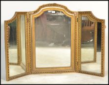 An early 20th Century Edwardian gilt triptech mirror, plaster on wood frame with central swing