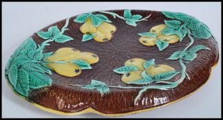 A 19th century Victorian Majolica ceramic bread board plate depicting pears and vine on brown log