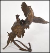 A bronze figurine sculpture of a pair of fighting grouse by Michael Simpson, stamped to the base MS,