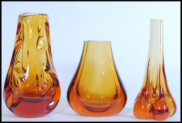 A group of Geoffrey Baxter for Whitefriars amber glass vases including a molar form stem vase, a