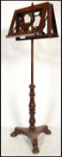 A 19th century rosewood and mahogany duet music stand raised on tripod hairy paw feet with carved