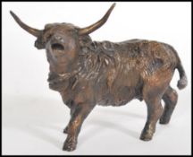 A bronze figurine of a highland cow in motion by Michael Simpson, stamped MS to the base, limited