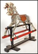 A vintage early 20th century Edwardian rocking horse raised on wooden rocking base with painted