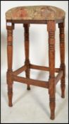 A 19th century Victorian mahogany tall teachers stool raised on turned legs with peripheral