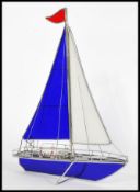 A 20th century blue and white glass and white metal sailing boat model with blue and white