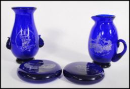 A collection of four pieces of Bristol Blue Glass to include a pair of twin handled vases and a pair