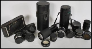 A collection of vintage 20th Century cameras and lenses to include a Kodak folding camera with red