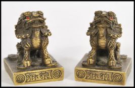 A pair of unusual brass Chinese temple / foo dog scroll weights. Each with brass plinth bases having