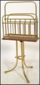 A 19th century Victorian brass and oak magazine stand  raised on cylindrical tripod base with