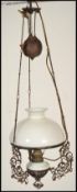 A late 19th Century brass rise and fall ceiling oil light with milk glass shade having a later