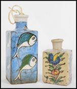 Two early 20th century Qajar style Persian ceramic flask/ bottle vases, the smaller having hand