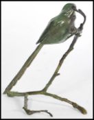 A bronze cold cast figurine of a tit perched on a branch signed by P. A. Northcroft to the base,