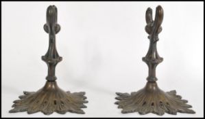 A pair of 19th century bronze scroll holders raised on acanthus leaf bases with reeded taurus shaped
