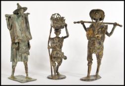 A set of 3 unusual large 20th century Chinese bronze figurines. One with merchant carrying basket,