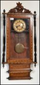 A 19th century Victorian wall clock having turned columns with carved pediment decoration. The white