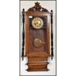 A 19th century Victorian wall clock having turned columns with carved pediment decoration. The white