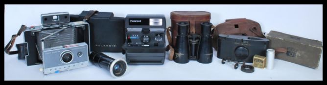 A collection of vintage cameras to include a Polaroid automatic 100 Land Camera, another Polaroid, a