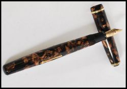A vintage 20th Century Wyvern lever filled fountain / Ink pen, the mottled pen on brown ground