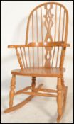 A 20th century beech wood rocking chair with a vase and slat back, solid seat pad raised on ring