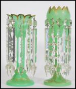 A pair of 19th century Victorian green glass lustres with with crenelated rims, having ten prismatic