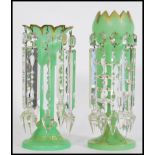 A pair of 19th century Victorian green glass lustres with with crenelated rims, having ten prismatic