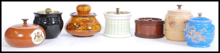 A selection of vintage tobacco jars to include a brown bulbous form jar with a travelling scene