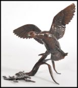 A bronze figurine of a goose in flight with reeds and water, by Michael Simpson, stamped MS to to
