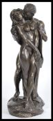 A bronzed sculptural figure group modelled as an entwined naked couple embraces in a loving position