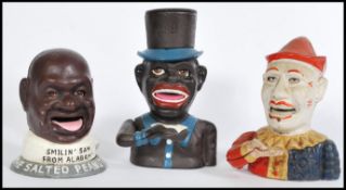 A collection of three cast metal 20th Century money boxes to include Smiling Sam From Alabama The